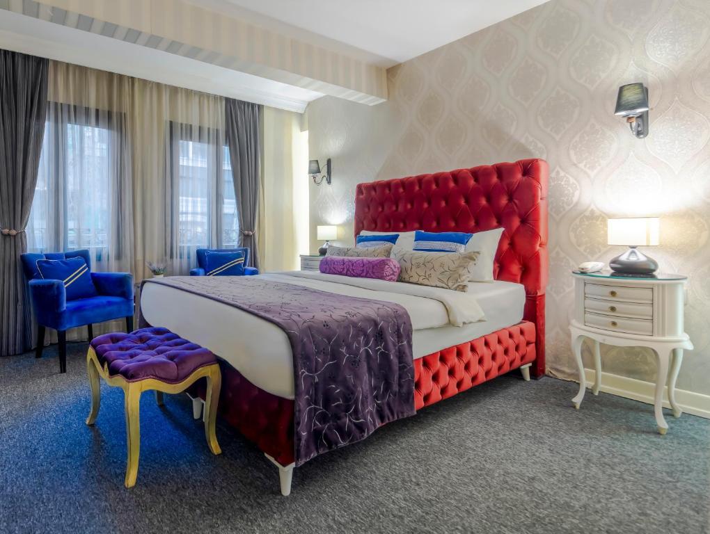 1 dormitorio con 1 cama grande y cabecero rojo en In Pera Boutique Hotel, en Estambul