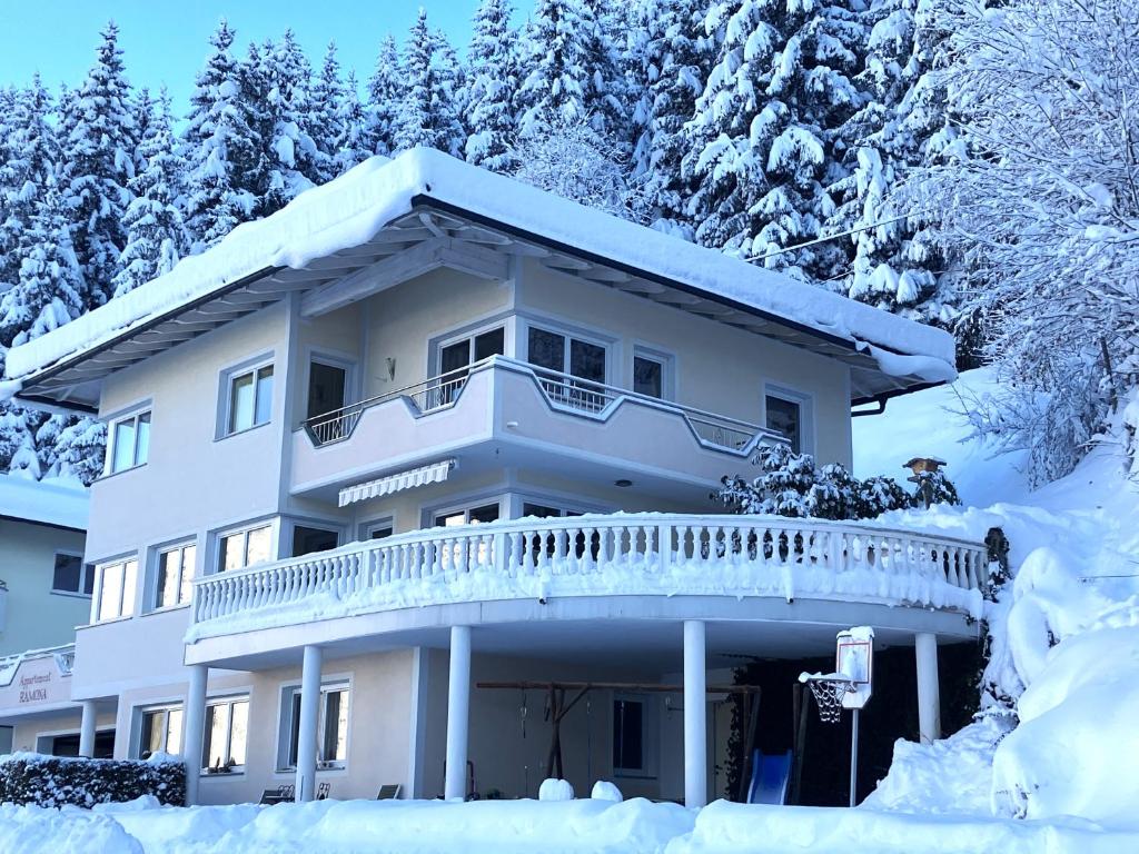 a house with a balcony in the snow at Appartement Ramona in Hainzenberg