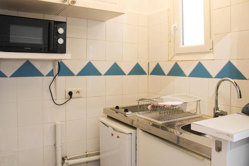 kuchnia ze zlewem i kuchenką mikrofalową w obiekcie Bright studio located near Paris w mieście Pantin