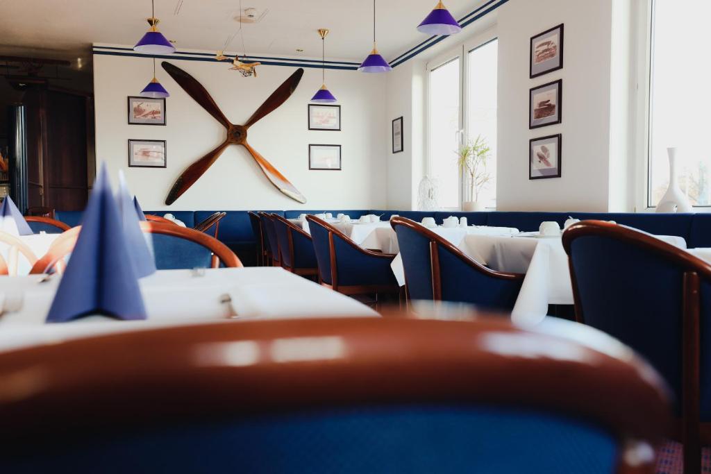 a restaurant with tables and chairs with a clock on the wall at Hotel Bavaria Brehna in Brehna