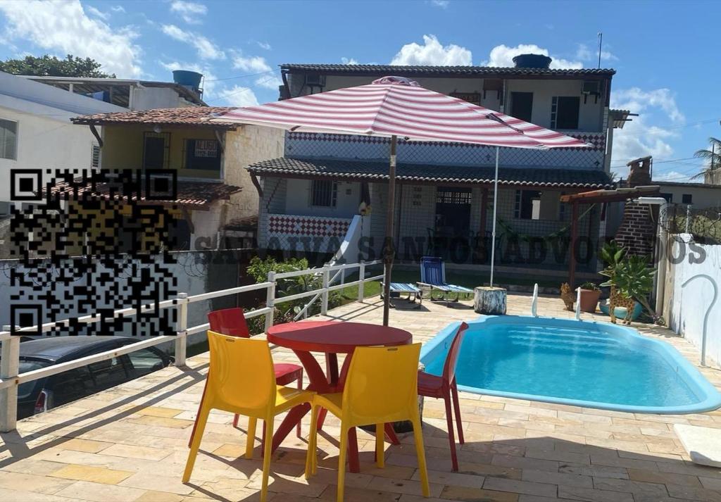 d'une terrasse avec une table et des chaises à côté de la piscine. dans l'établissement CASA DE PRAIA AV BEIRA MAR, à Cabo de Santo Agostinho