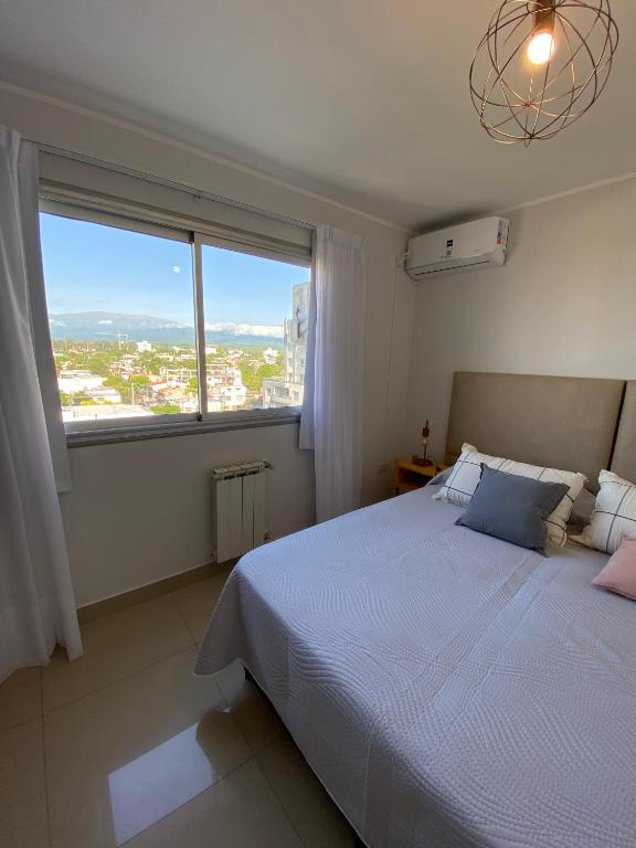 a bedroom with a large bed and a large window at Departamento espacioso en Salta in Salta