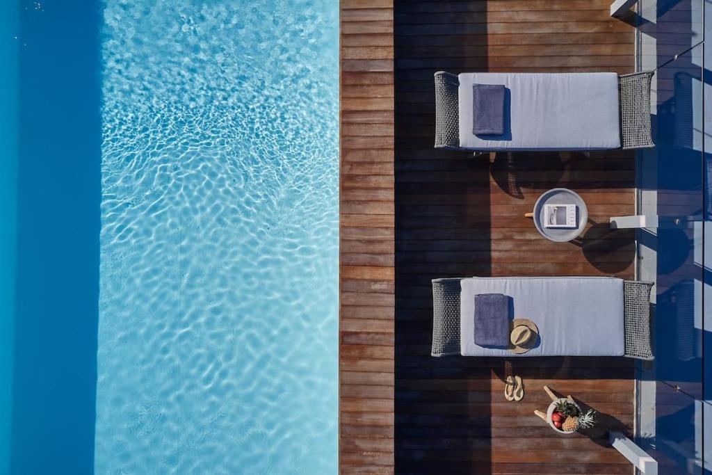 an overhead view of a swimming pool with a person sitting on a chair at CW Athens Riviera Suite in Athens