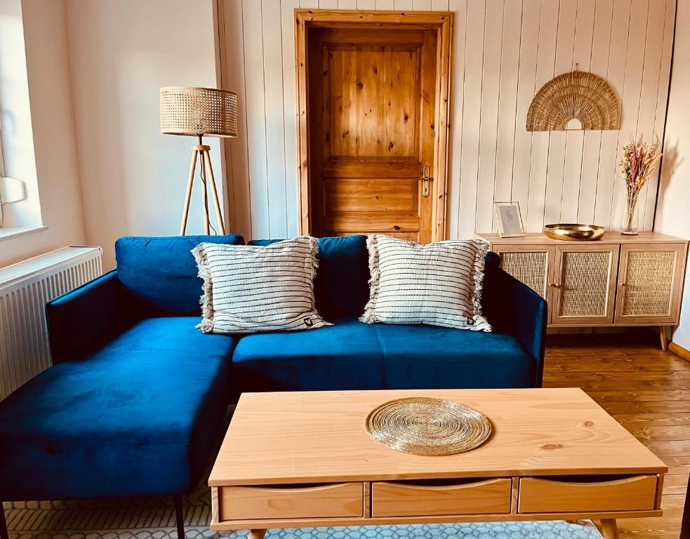Sofá azul en la sala de estar con mesa de centro en Ferienwohnung für die ganze Familie (Hunde willkommen!), en Zehdenick