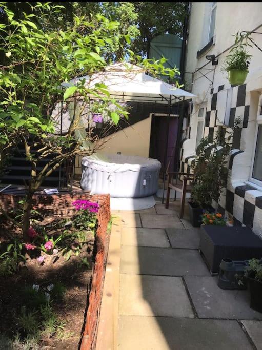 a garden with a large tub sitting next to a building at The Old Post Office, Knaresborough in Knaresborough