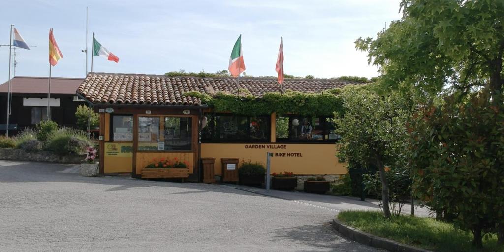 ein gelbes Gebäude mit Flaggen darüber in der Unterkunft Garden Village San Marino in San Marino