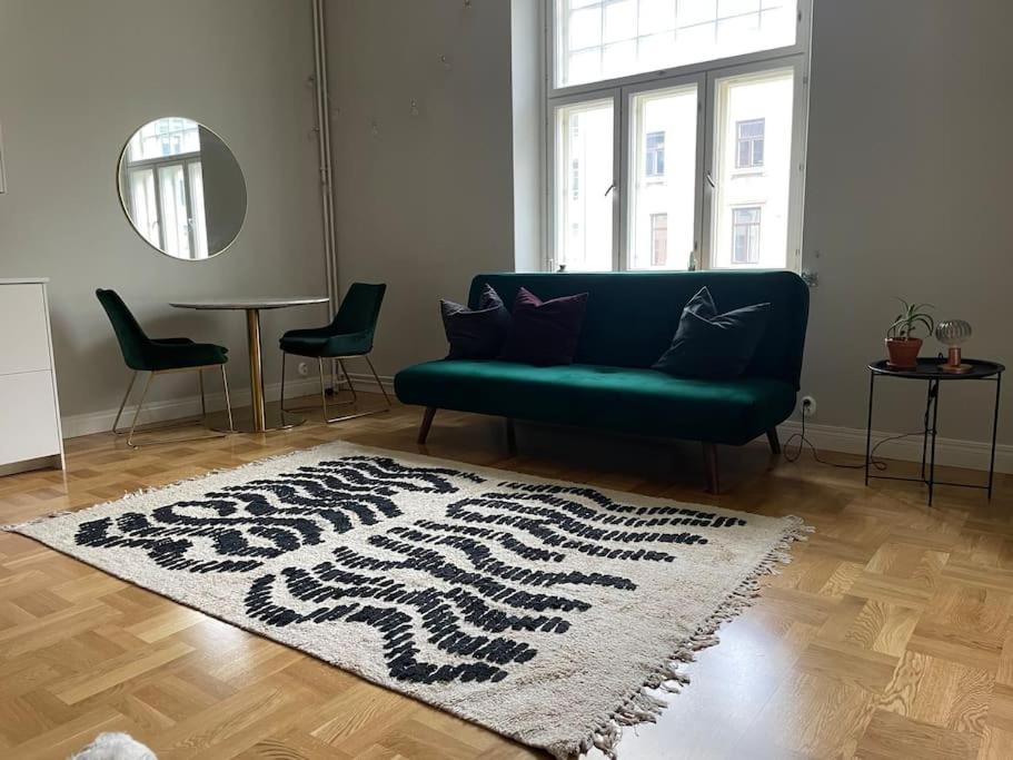 - un salon avec un canapé vert et un tapis dans l'établissement Yksiö Punavuoresta, à Helsinki