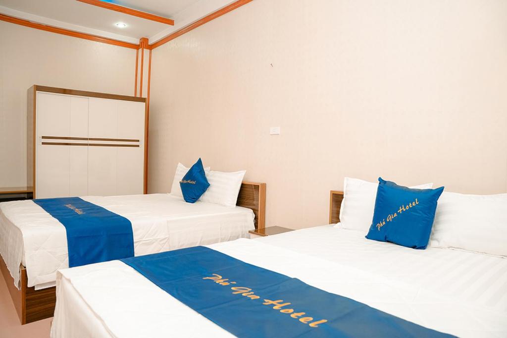 2 camas en una habitación de color azul y blanco en PHU GIA HOTEL - KHÁCH SẠN BẮC NINH, 