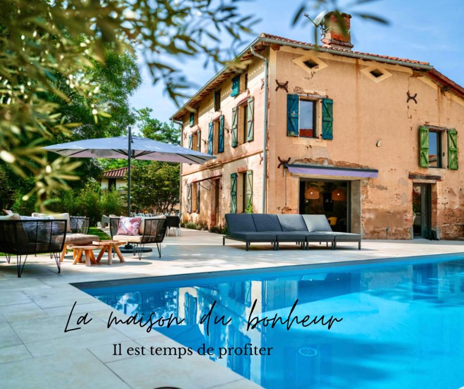 una casa con piscina frente a una casa en La Maison du Bonheur - Grande Piscine & Terrasse, en Brens