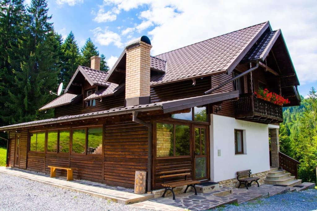 a log home with a roof and windows at Cabana din poiană in Câmpulung Moldovenesc