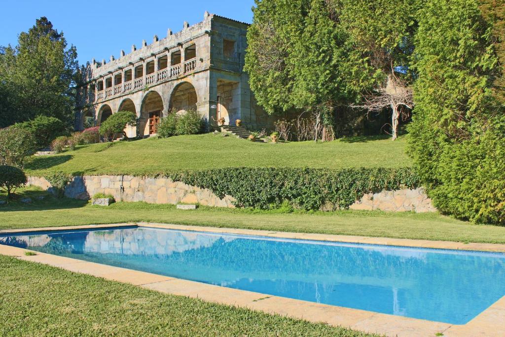 una piscina frente a una casa grande en Pazo de Villares, en Gondomar