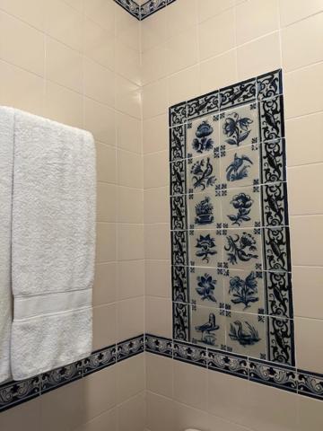 a bathroom with a blue and white patterned shower curtain at Casa dos três rapazes in Monte Córdova
