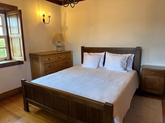 a bedroom with a large bed with white sheets and pillows at Casa dos três rapazes in Monte Córdova