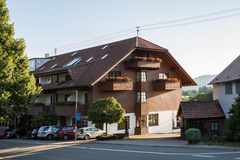 ein großes Backsteingebäude mit Blumenkästen drauf in der Unterkunft Hotel Restaurant Vinothek LAMM in Bad Herrenalb