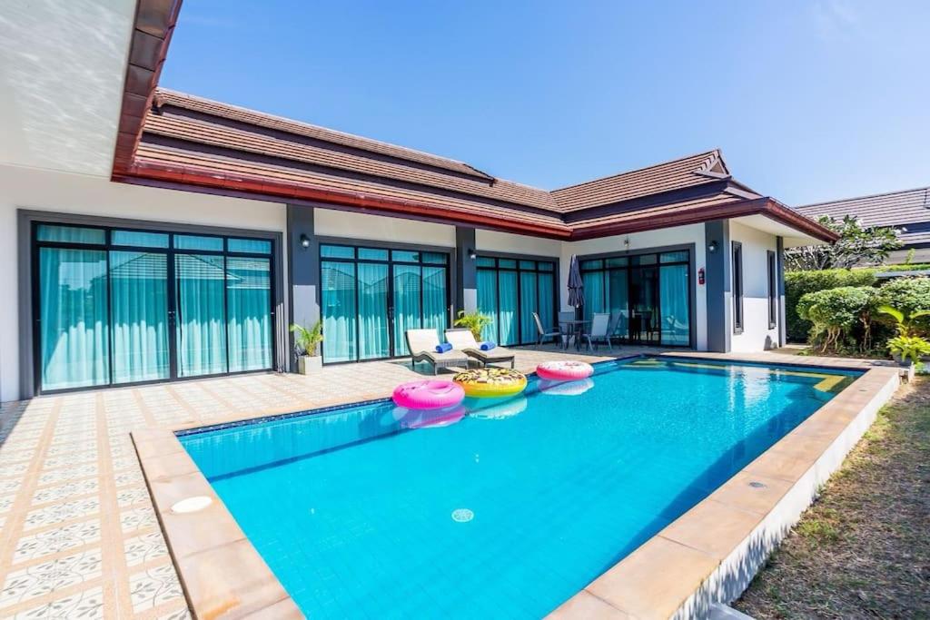 a swimming pool in the backyard of a house at Villa ABBIE ! Amazing Pool Villa for family and Friends in Hua Hin