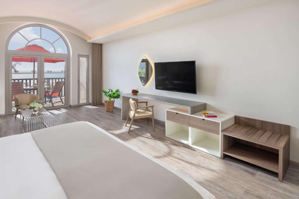a living room with a bed and a tv at JA Palm Tree Court, Dubai in Dubai
