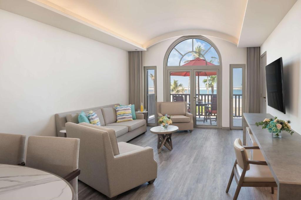 a living room with a couch and a table at JA Palm Tree Court, Dubai in Dubai