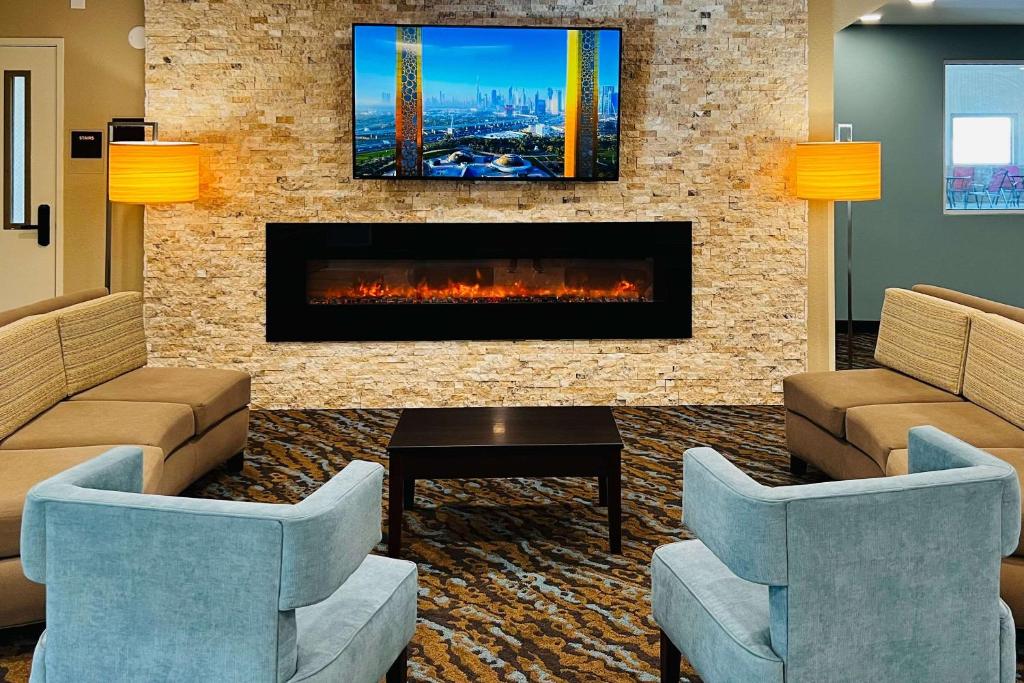 vestíbulo con chimenea, 2 sillas y TV en Sleep Inn & Suites Lake Delton-Wisconsin Dells Newly Renovated 2024, en Wisconsin Dells