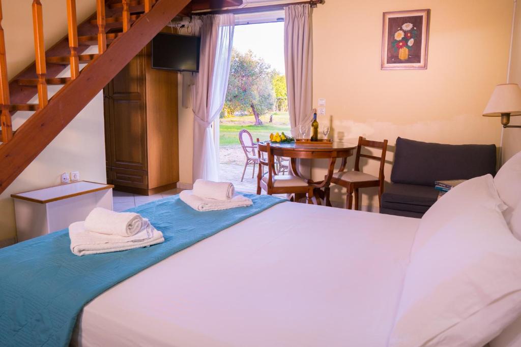 a bedroom with a bed and a dining room at Olive Τrees Garden in Lixouri