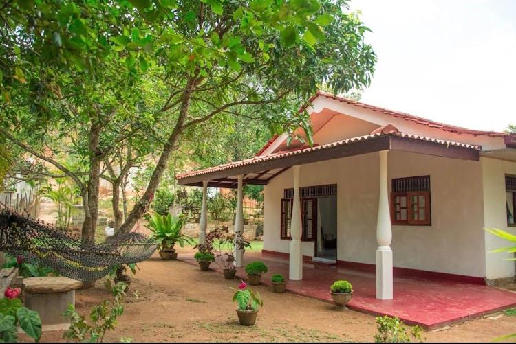 a small house with a hammock in front of it at Mango villa in Unawatuna