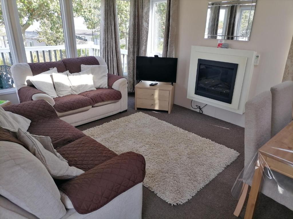 ein Wohnzimmer mit einem Sofa und einem Kamin in der Unterkunft Kent Coast Holiday Park in Rochester