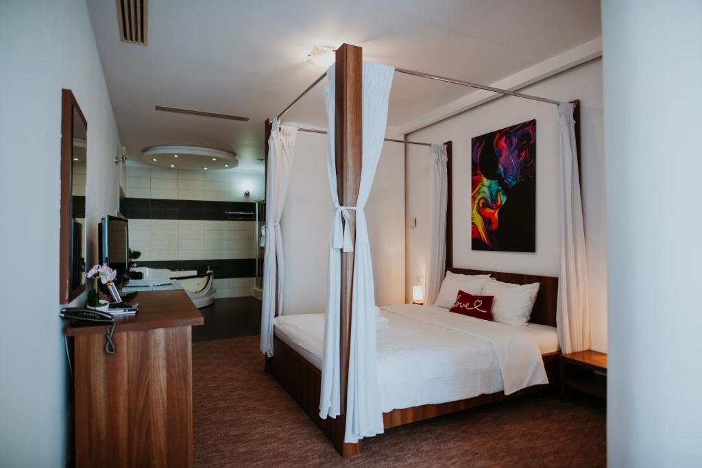 - une chambre avec un lit à baldaquin et une salle de bains dans l'établissement Hotel Select, à Sibiu