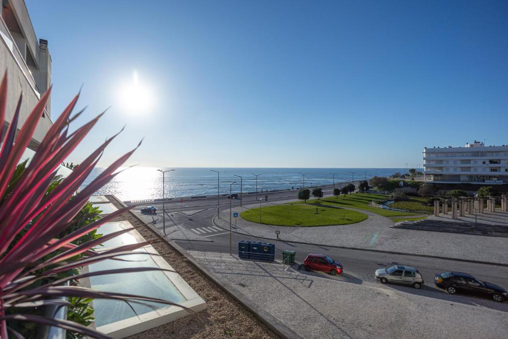 a view of a street with cars on the road and the ocean at Buarcos Ocean Village in Buarcos
