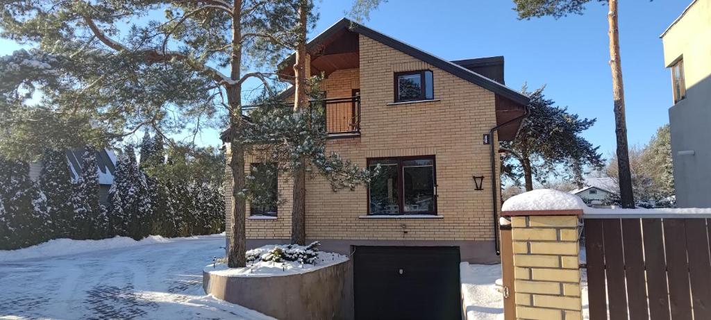 a brick house with a garage in the snow at Radikiai House 