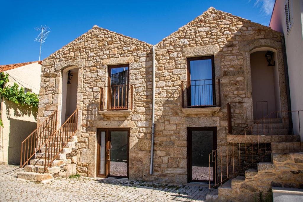 una vieja casa de piedra con escaleras en una calle en DOURO FAMILY 2BD Apartment, en São João da Pesqueira