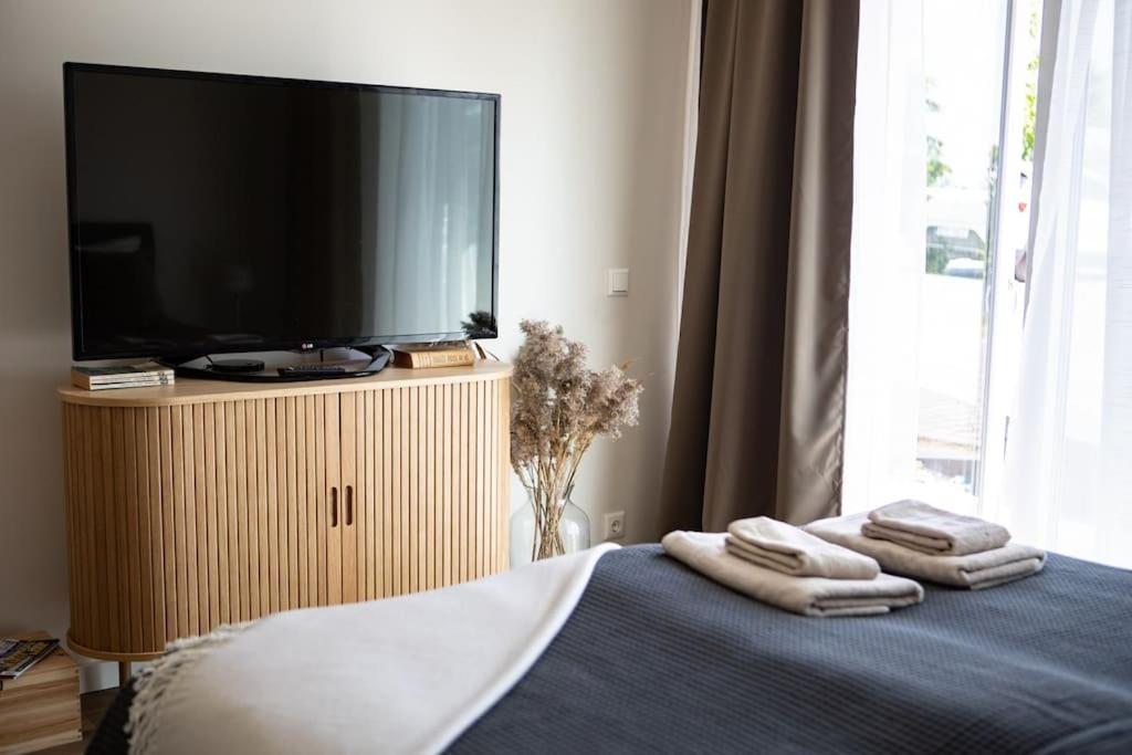 a bedroom with a tv and towels on a bed at Järvevaatega apartment in Viljandi