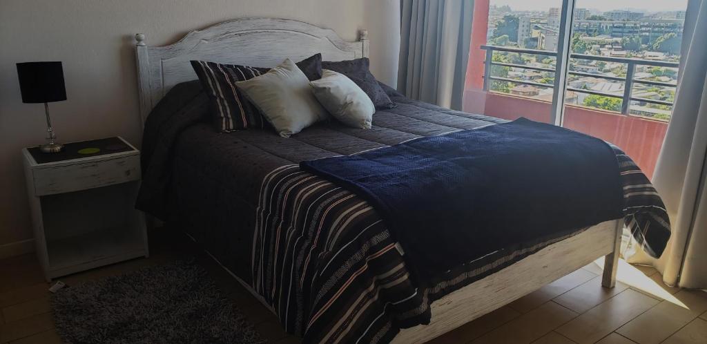 a bedroom with a bed with a view of the city at Mirador Uno in Concepción