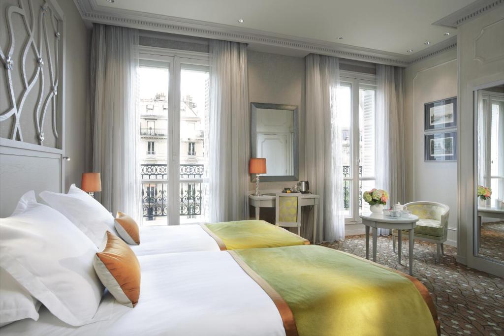 a bedroom with a large white bed with white pillows at Splendid Etoile in Paris
