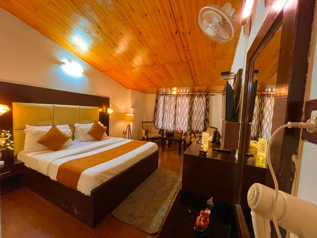 a bedroom with a large bed with a wooden ceiling at Hotel The North Wind in City Center, Manali in Manāli