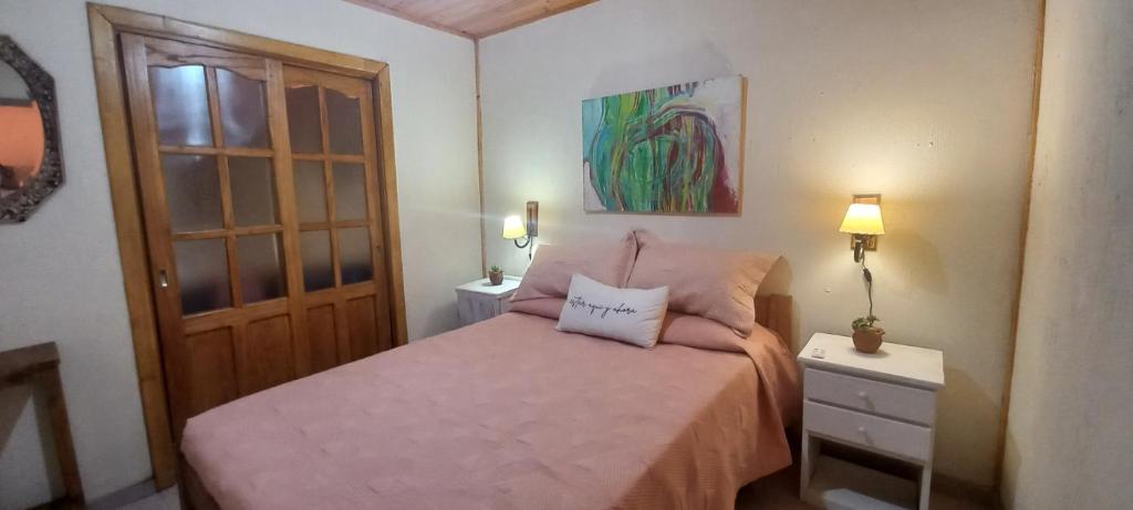 a bedroom with a bed with a pink bedspread at Rincón de Afrodita in San Lorenzo