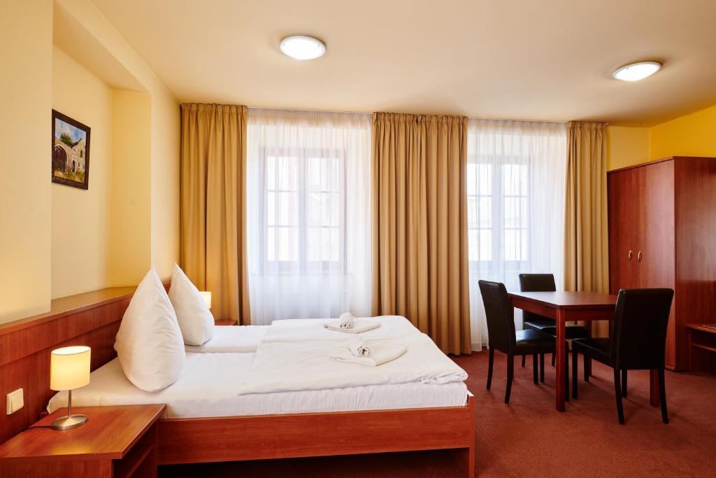 a hotel room with a bed and a table at Hotel Zlatá Hvězda in Vimperk