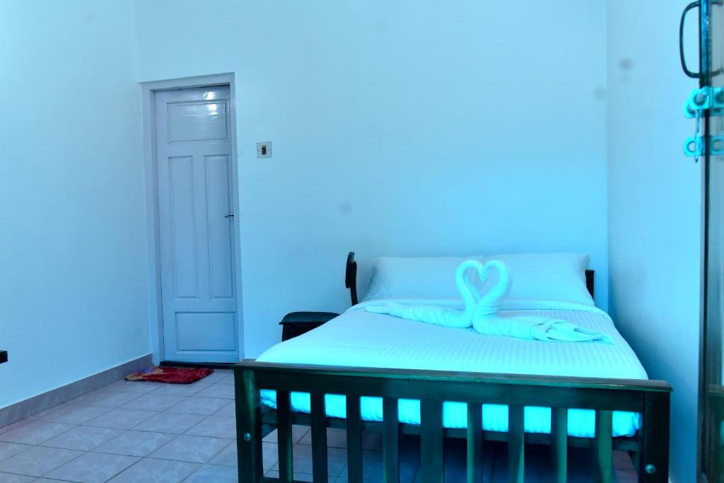 a blue room with a bed with a bow on it at Suryas Rooms in Varkala