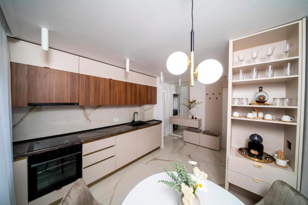 a kitchen with white cabinets and a white table at Est One Apartament 2 camere semidecomandat in Drobeta-Turnu Severin