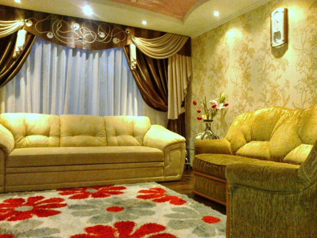 a living room with two couches and a rug at Apartamenty Kharkovskaya in Sumy