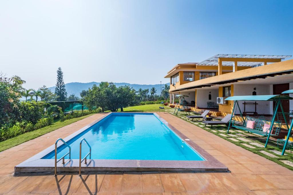 an image of a swimming pool at a house at SaffronStays Le Farm By The Lake In Kamshet in Somavadi