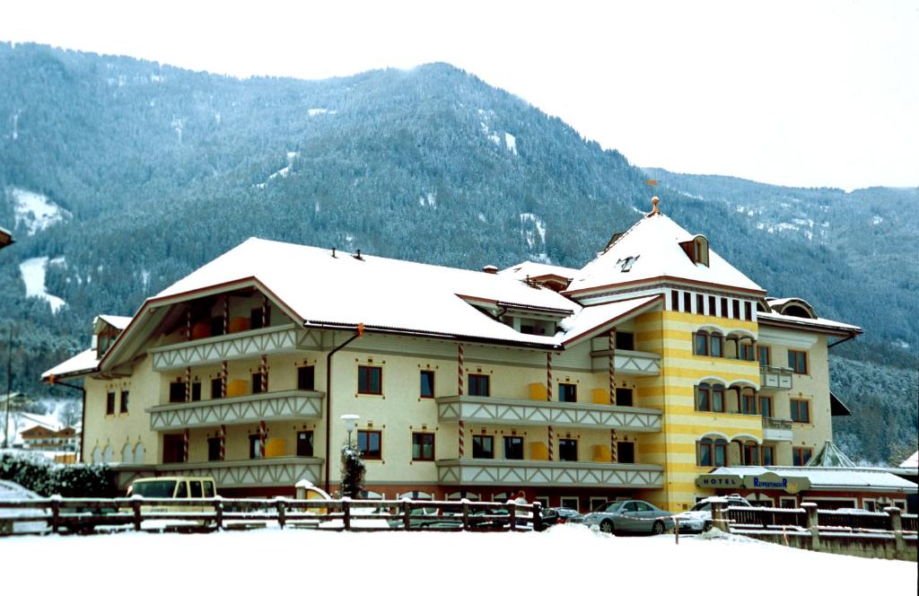 ein großes Gebäude mit einem schneebedeckten Dach in der Unterkunft Hotel Reipertingerhof in Bruneck