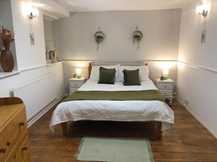 Beautiful 2 bedroom garden flat in great location في بريستول: غرفة نوم بسرير كبير مع مواقف ليلتين
