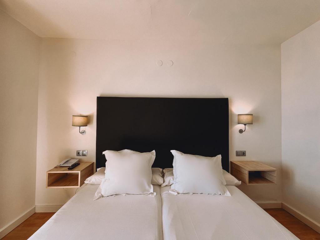 a bedroom with a large white bed with two pillows at FAY Victoria Beach in Rincón de la Victoria