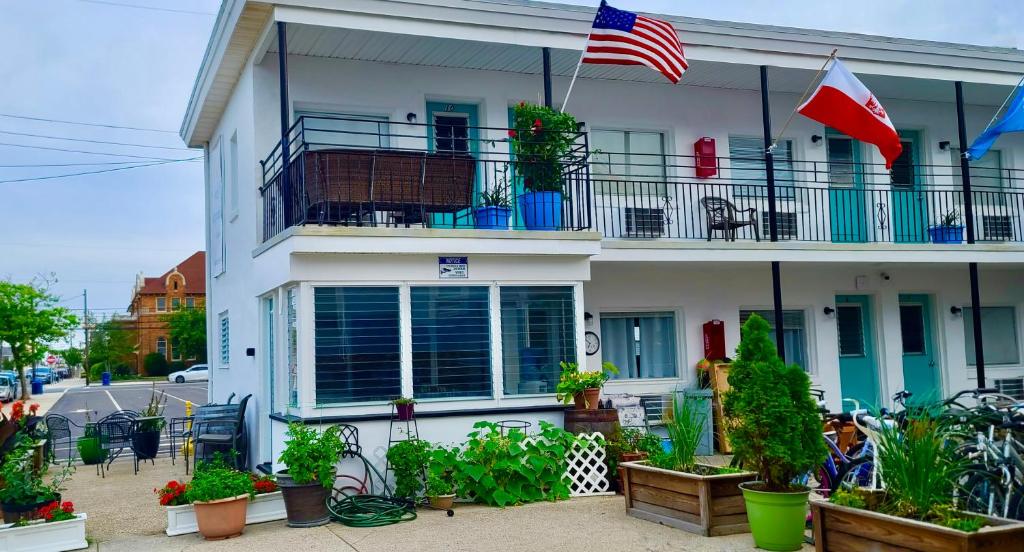 a white house with an american flag on a balcony at Hotel on Magnolia East 'HOME' in Wildwood