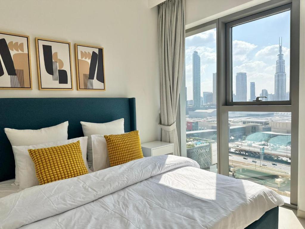 sypialnia z łóżkiem i dużym oknem w obiekcie Luxury Apartment Downtown Dubai Mall Burj Khalifa View free Netflix & Prime Video w Dubaju
