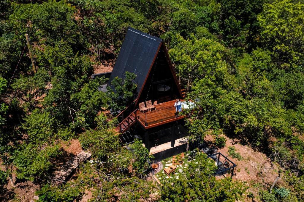 an overhead view of a house with a black roof at Cabana Arizona no The Country Huts in Novo Gama