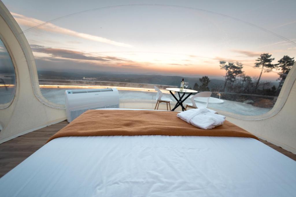 a bedroom with a bed and a view of the ocean at Glamping Balú in Monesterio
