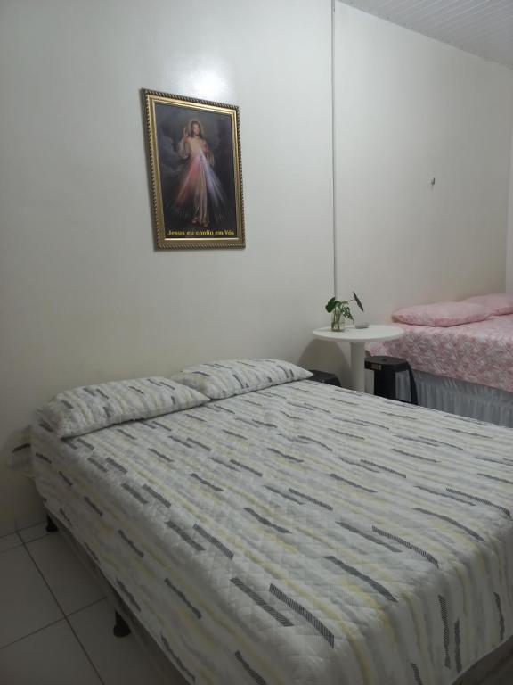 a bedroom with a bed and a picture on the wall at Pousada Residencial acochego caririense in Juazeiro do Norte