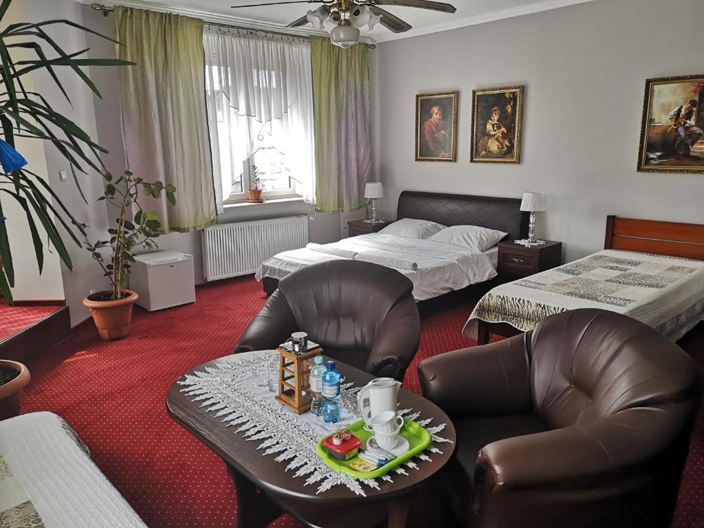 a bedroom with two beds and a table and chairs at Pokoje Goscinne&Pizzeria in Orzesze