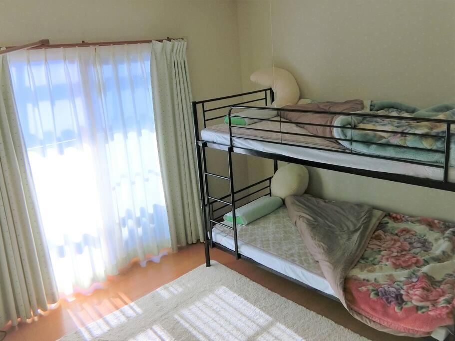 two bunk beds in a room with a window at 「けったもん」へようこそ！2階の1室でゆっくり休めます！ in Nagano