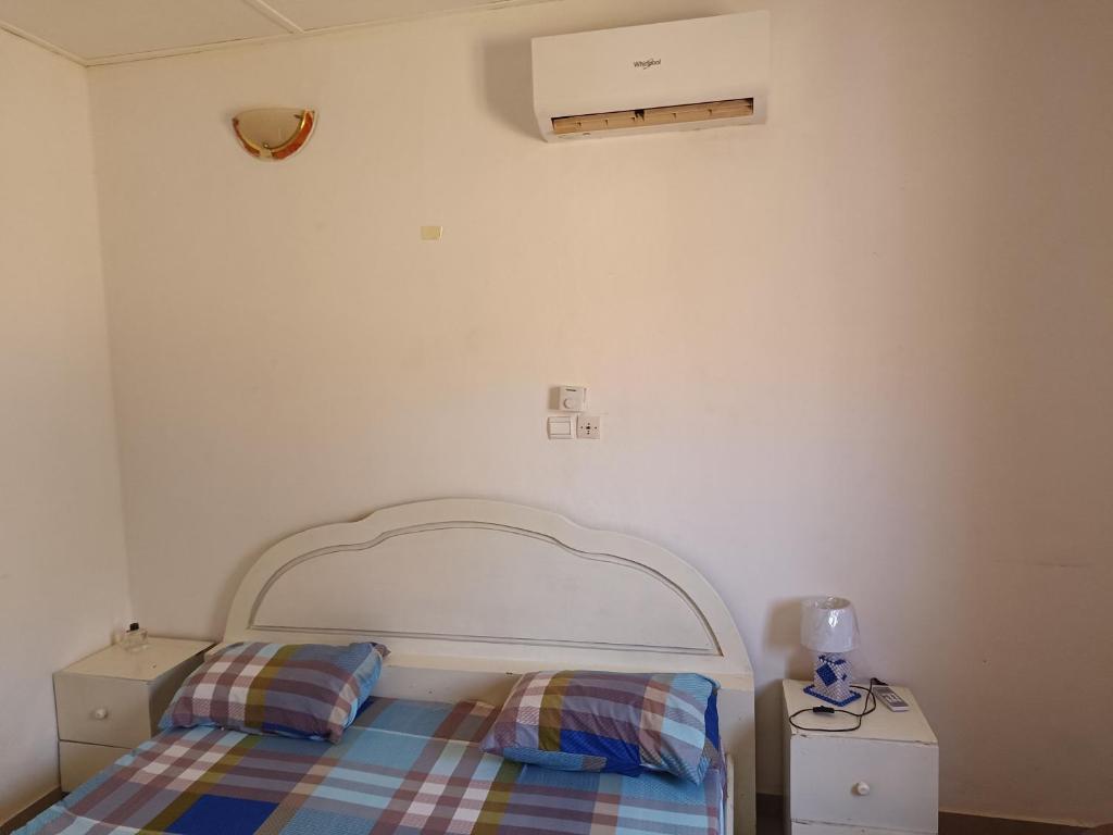 a bedroom with a bed with a white headboard at AKD Résidence et Automobile in Ouagadougou